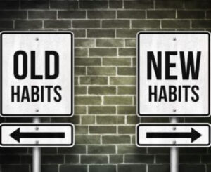 An arrow with a sign bad habits pointing one way and another with good habits point the opposite way 